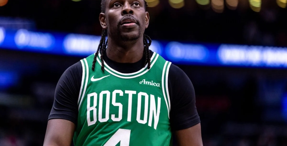 Jrue Holiday looking mildly upset in a green Celtics jersey.