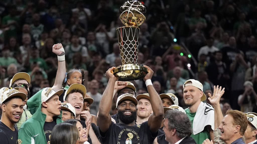 Boston Celtics star Jaylen Brown lifts the NBA Finals MVP trophy after winning the award in Boston's 2024 title win (NBA Finals MVP betting guide)