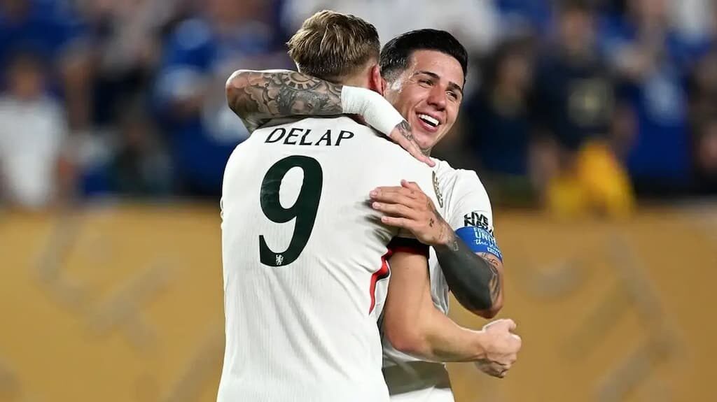 Chelsea players Liam Delap and Enzo Fernandez embrace in celebration during a match - Benfica vs. Chelsea Club World Cup Round of 16 Prediction, Picks & Odds cover